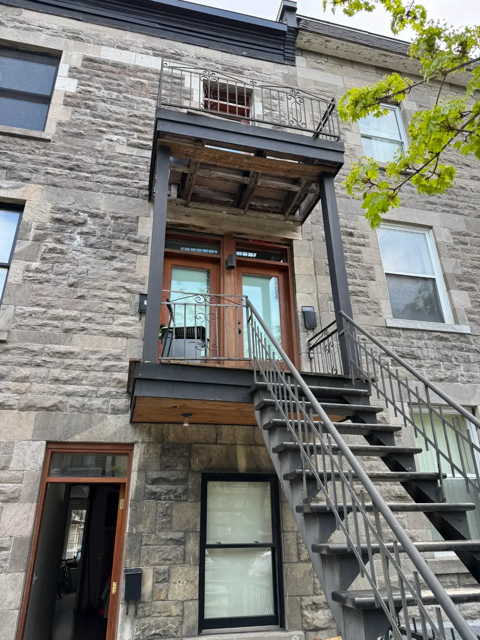 Réfection de balcons superposés Supports en acier, structure bois et soffites avec éclairage intégré. Harmonie parfaite avec la façade en pierre du Plateau Mont-Royal.